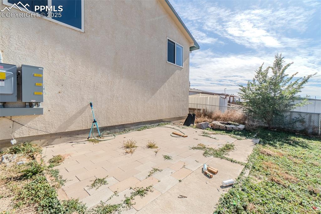 View of side of home with stucco siding and a patio