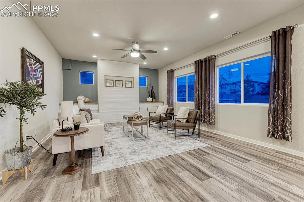 Living area with ceiling fan, light wood finished floors, and recessed lighting