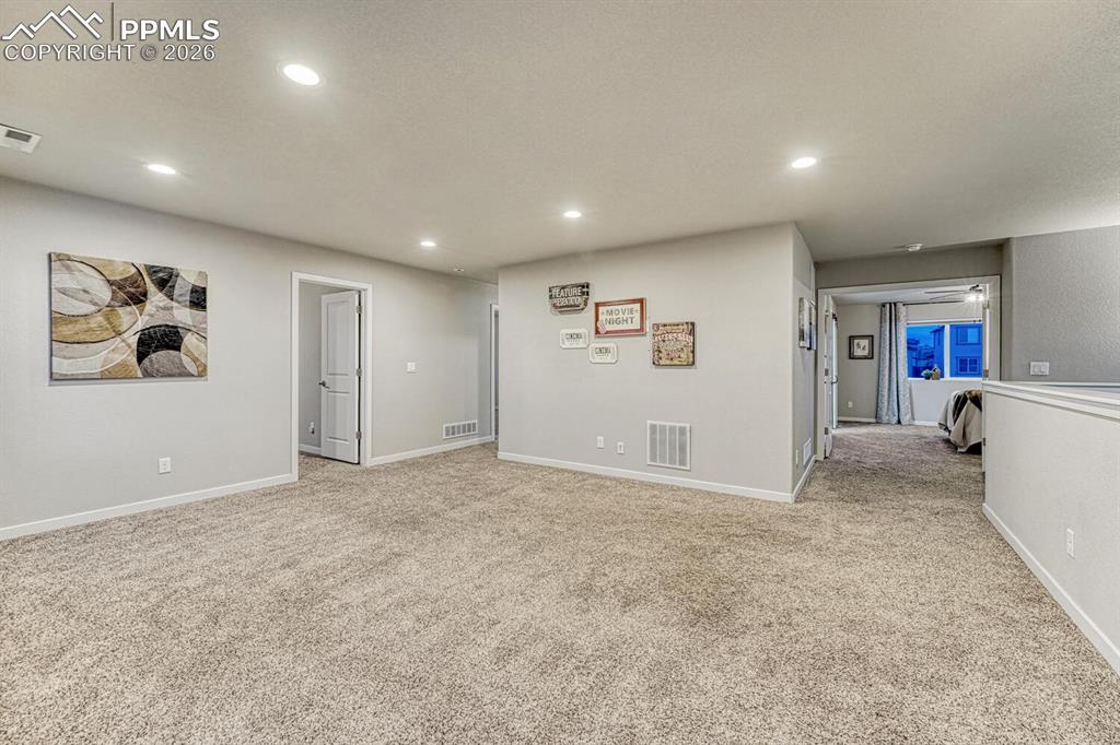 The great size of the loft is complemented by light carpet and recessed lighting.