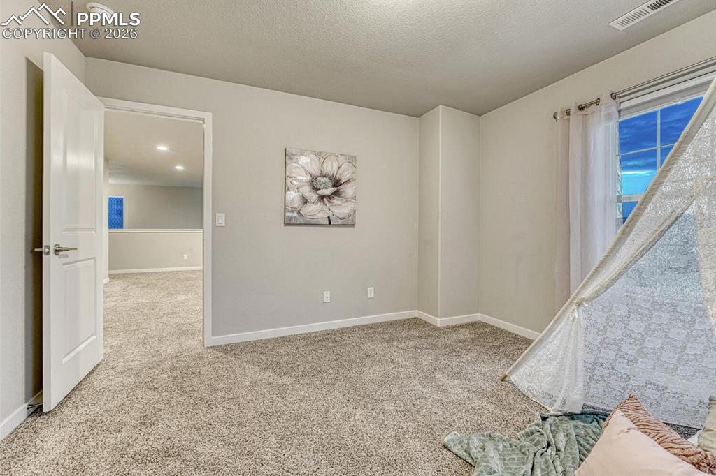 Empty room featuring light carpet and a textured ceiling