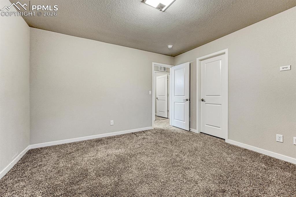 Unfurnished bedroom featuring carpet and a textured ceiling