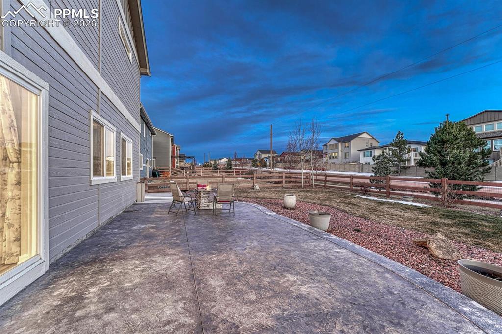 Fenced backyard with a patio area, an outdoor fire pit, and a residential view and Pikes Peak Veiw