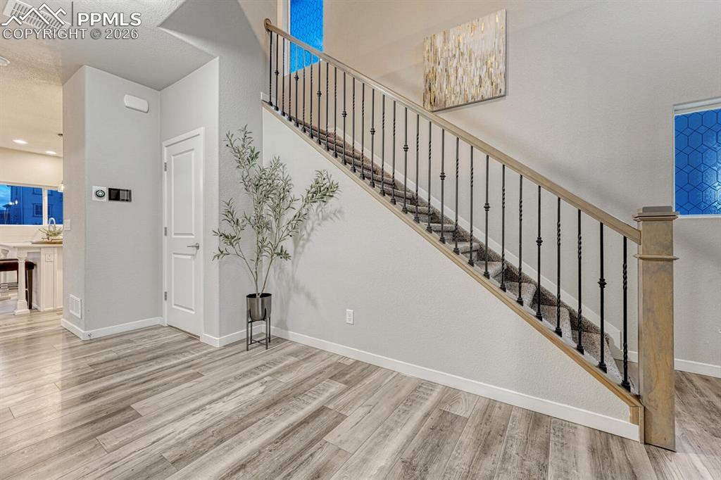 Stairway with wood finished floors and baseboards