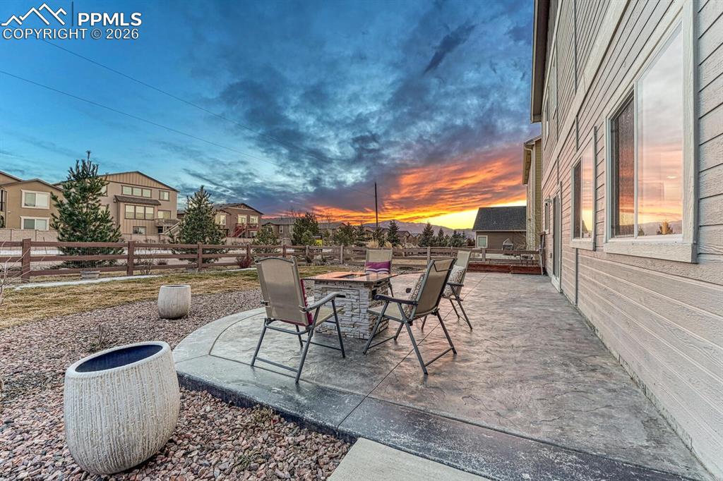 Fenced backyard with a patio area, an outdoor fire pit, and a residential view