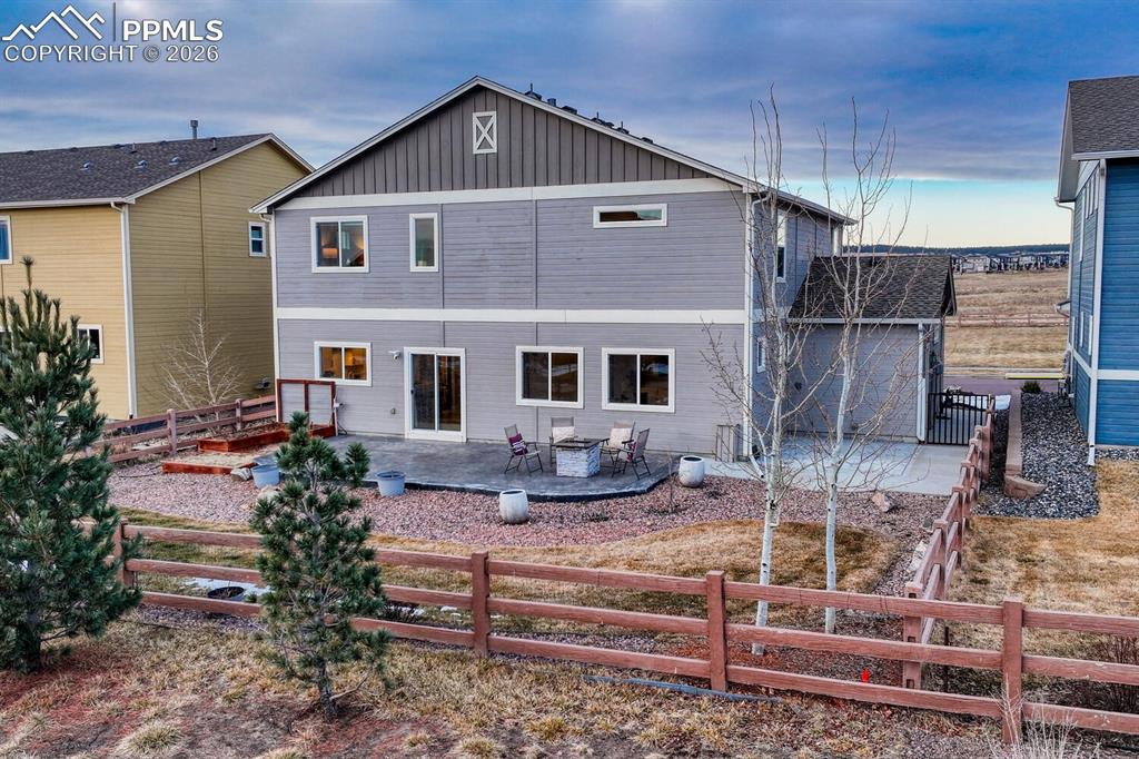 Back of house with a fenced backyard, a patio, and board and batten siding