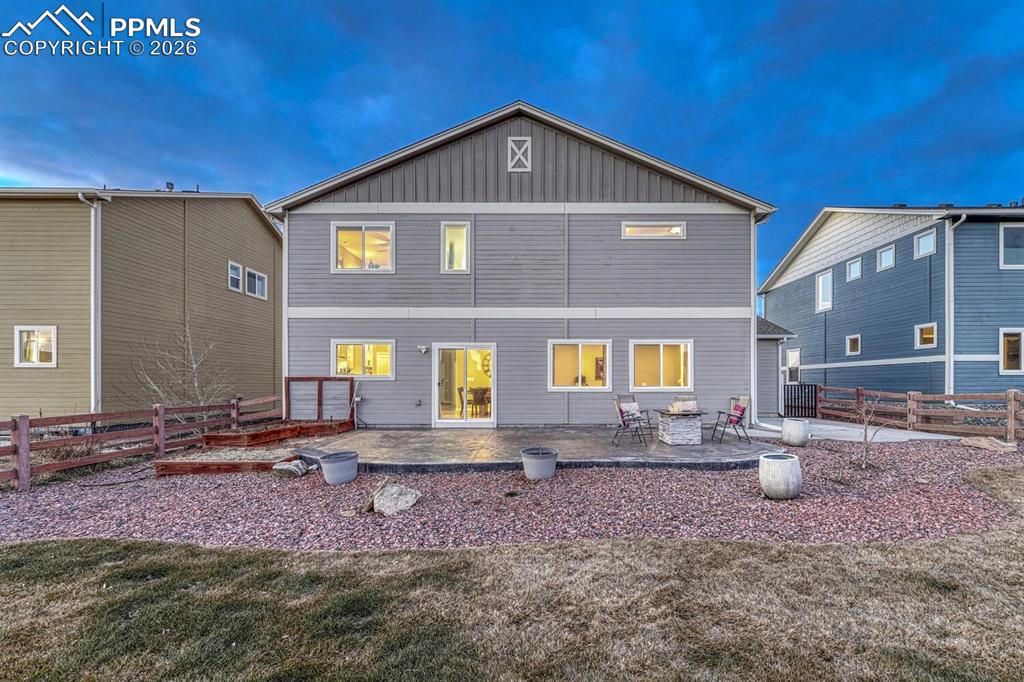 Back of house with a fenced backyard, a patio, and board and batten siding