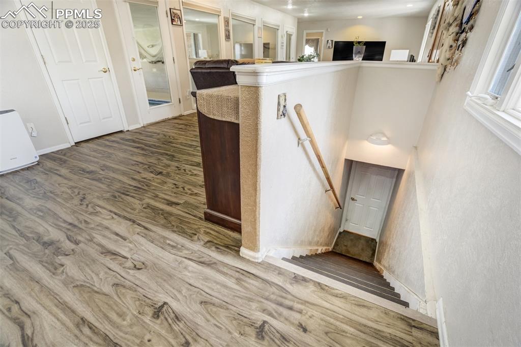 Staircase with wood finished floors and baseboards