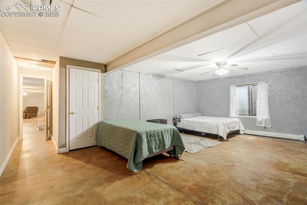 Bedroom with finished concrete floors, a 2 closets and storage room