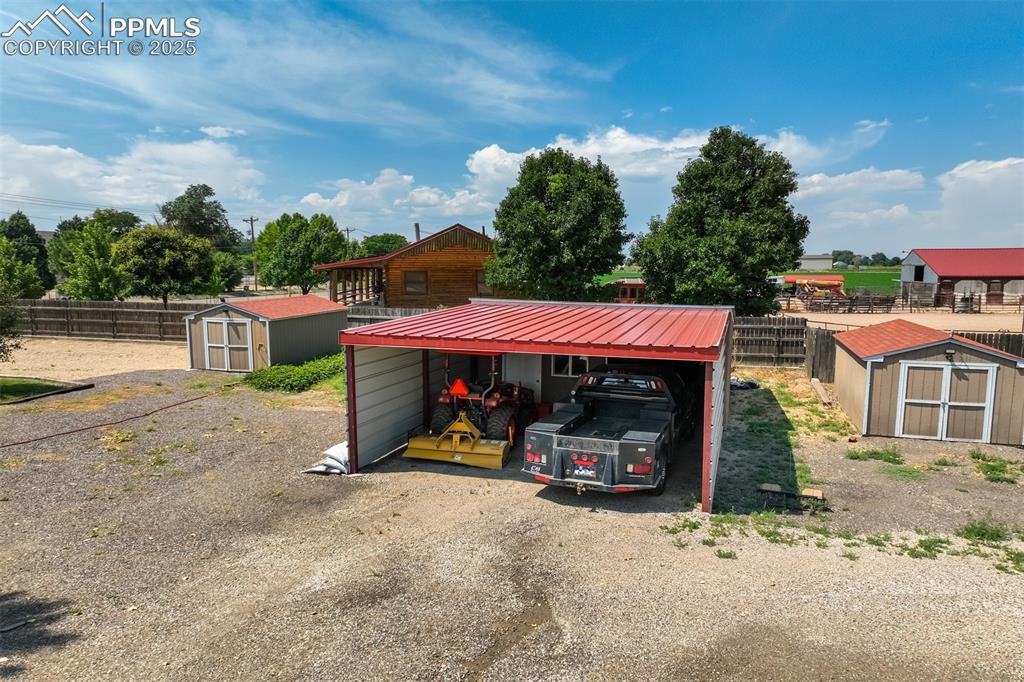 View of workshop attached to carport, and 2 sheds