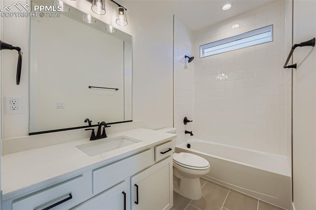 Bathroom featuring vanity,  shower combination, and light tile patterned floors