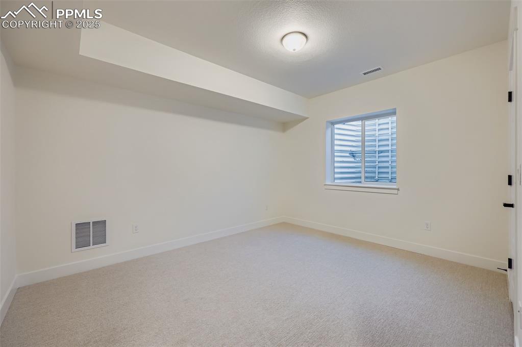 Unfurnished room featuring baseboards and light colored carpet