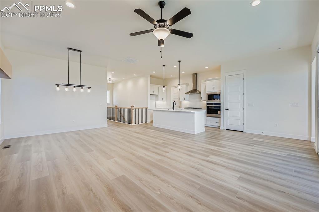 Unfurnished living room with recessed lighting, light wood-style floors, and ceiling fan