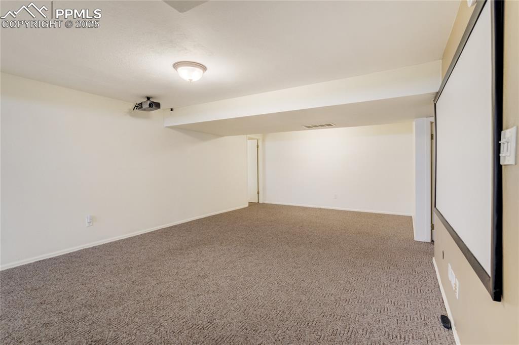 Finished below grade area with light colored carpet and baseboards