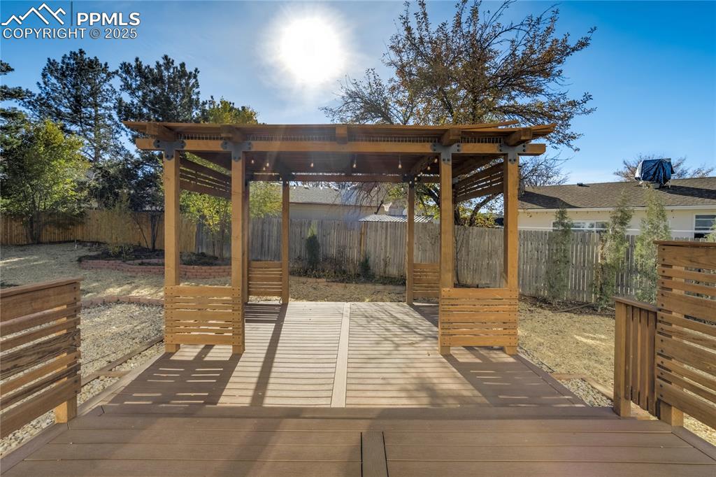 Fully fenced backyard with custom 2-tier deck with pergola