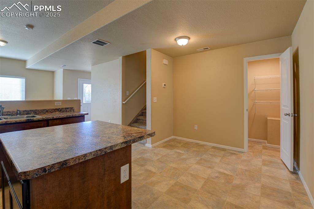 Kitchen with a textured ceiling, a center island, and dark countertops