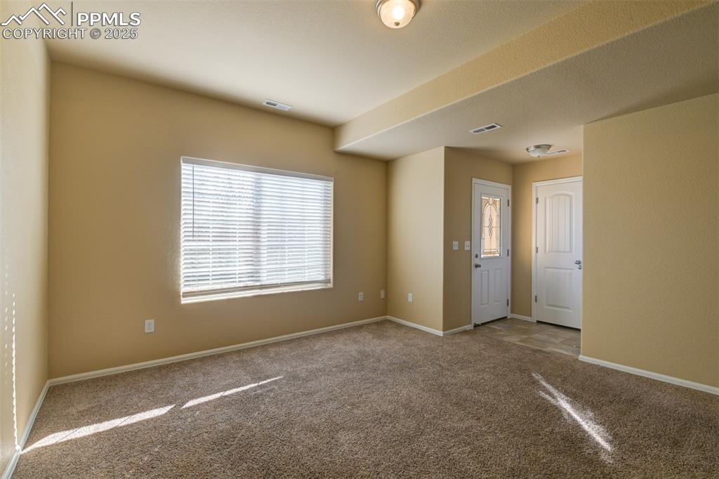Empty room with healthy amount of natural light and carpet floors