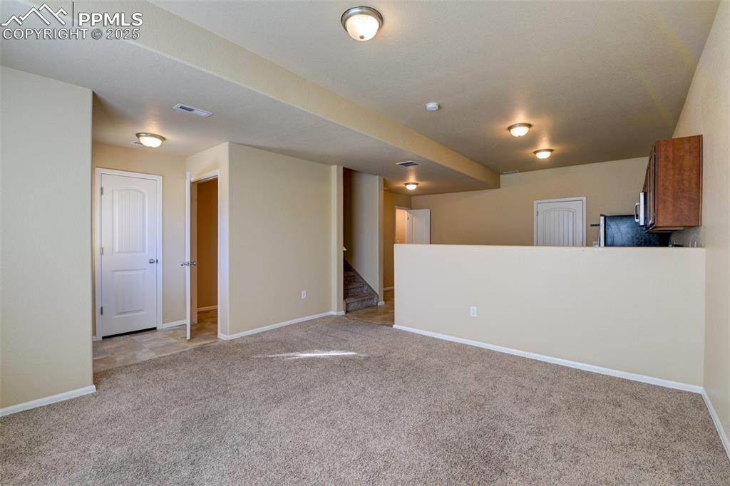 Spare room with light colored carpet and stairway