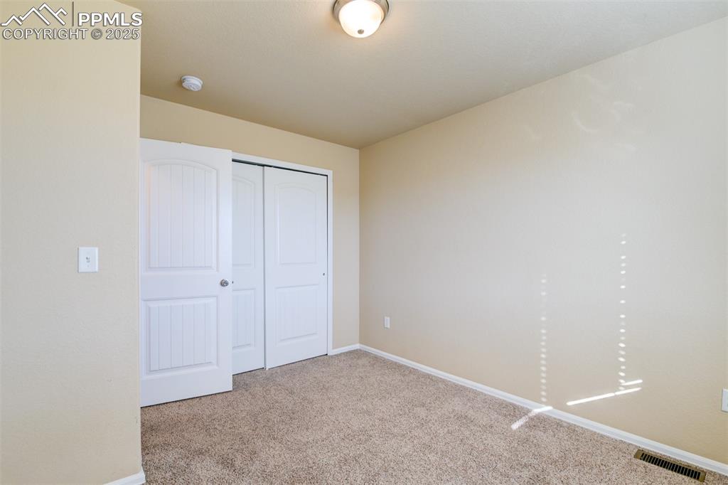 Unfurnished bedroom featuring carpet floors and a closet