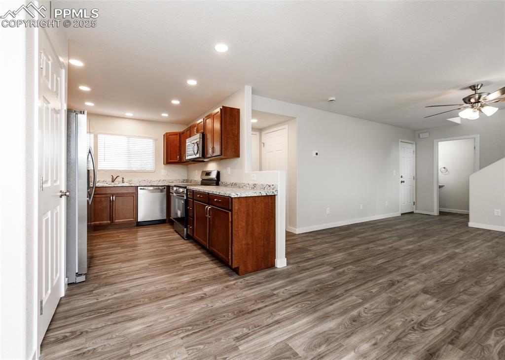 Kitchen featuring appliances with stainless steel finishes, light wood-type flooring, recessed lighting, open floor plan, and a ceiling fan
