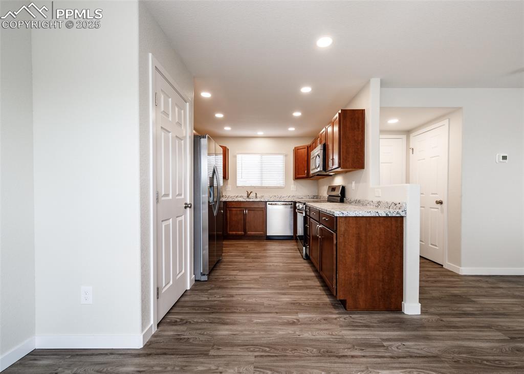 Kitchen with appliances with stainless steel finishes, dark wood-style flooring, and recessed lighting