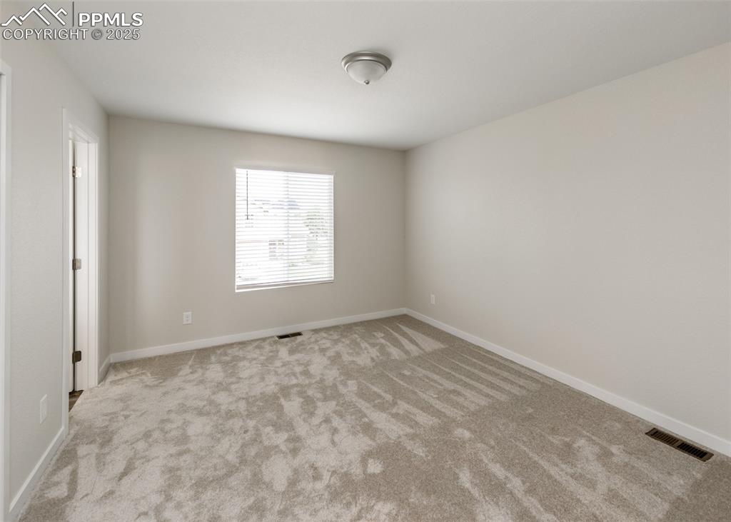 Empty room with carpet floors and baseboards