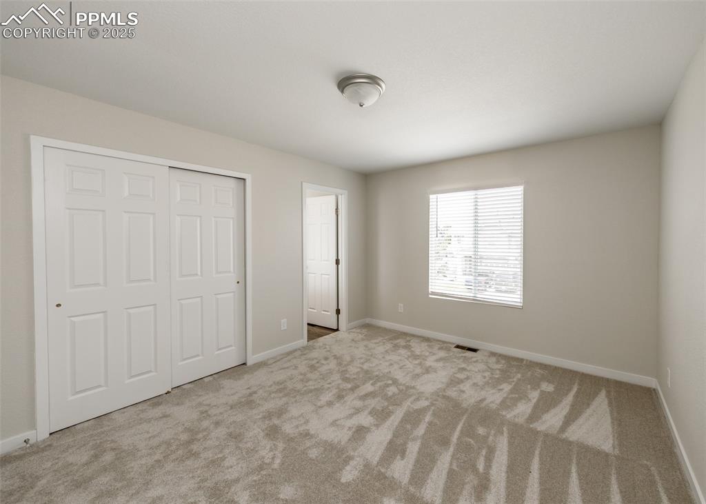 Unfurnished bedroom featuring carpet flooring and a closet