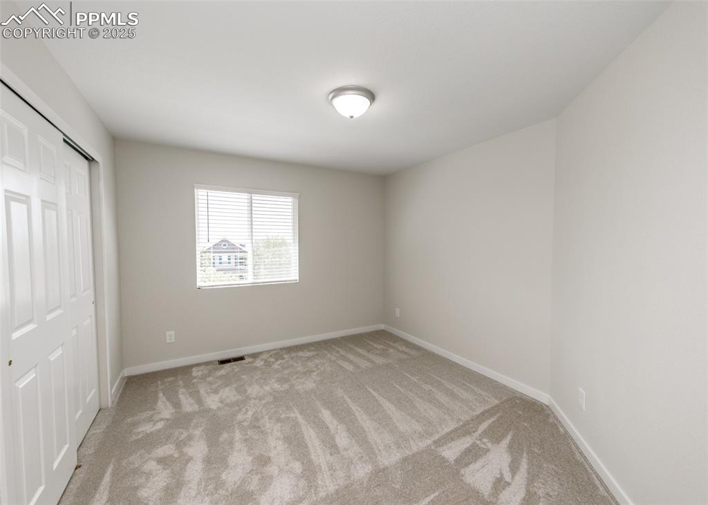 Unfurnished bedroom with a closet and light colored carpet