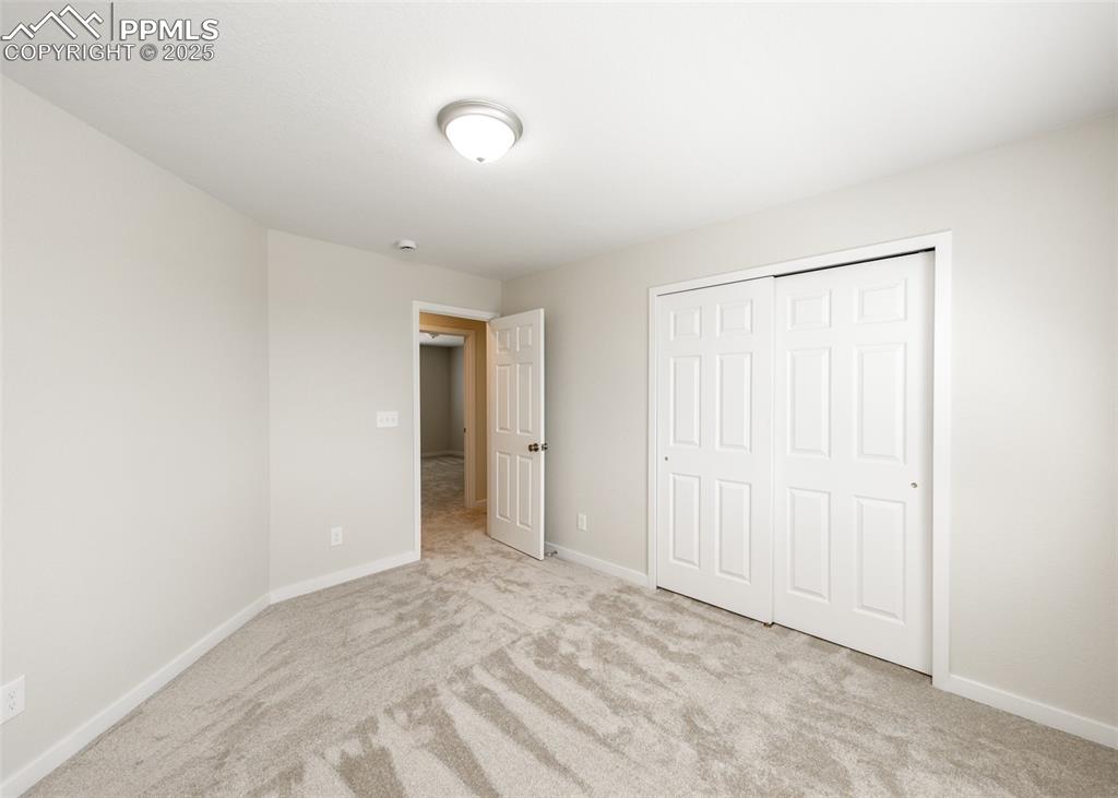 Unfurnished bedroom with light colored carpet and a closet