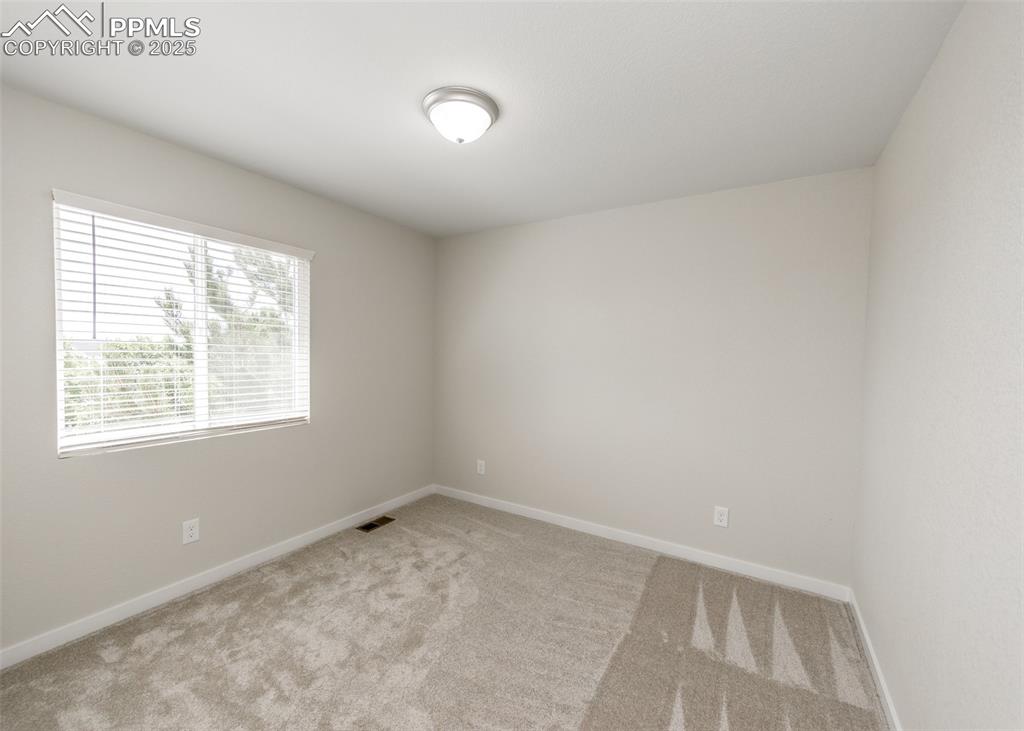 Spare room with carpet and baseboards