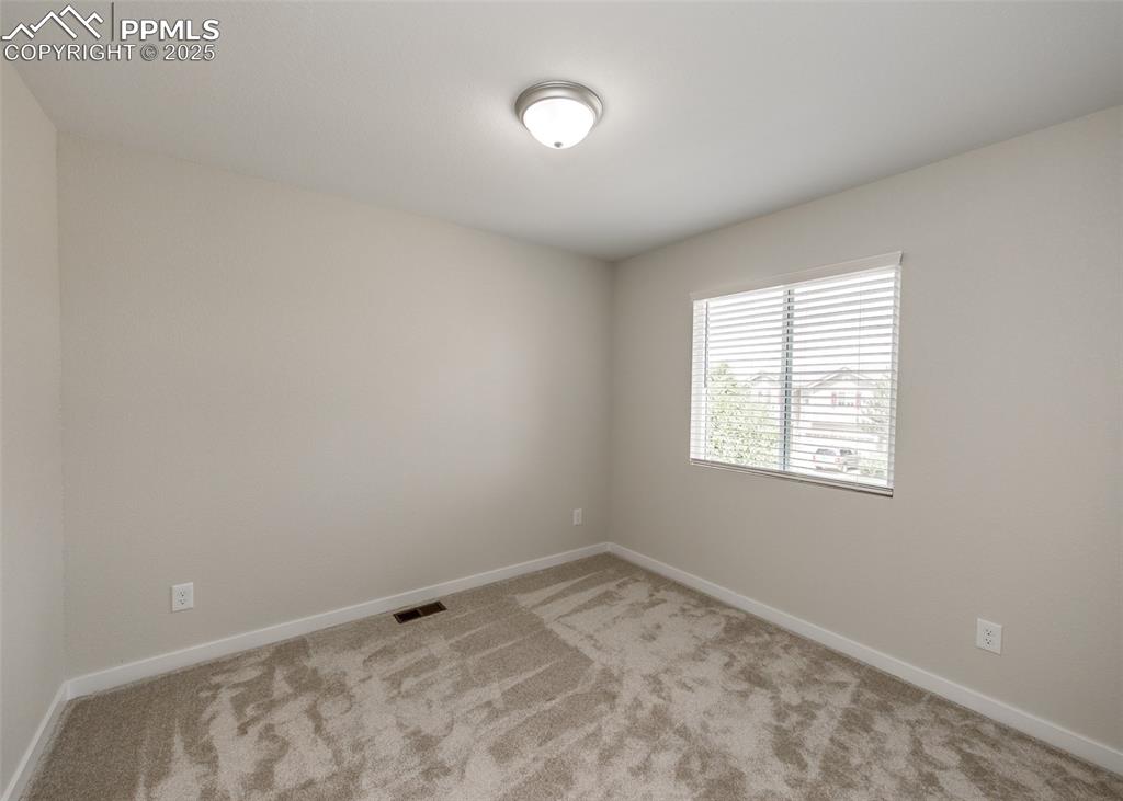 Carpeted spare room with baseboards