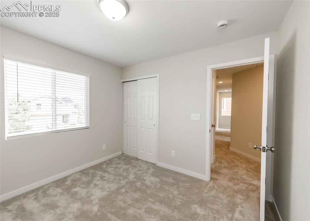 Unfurnished bedroom featuring light colored carpet and a closet