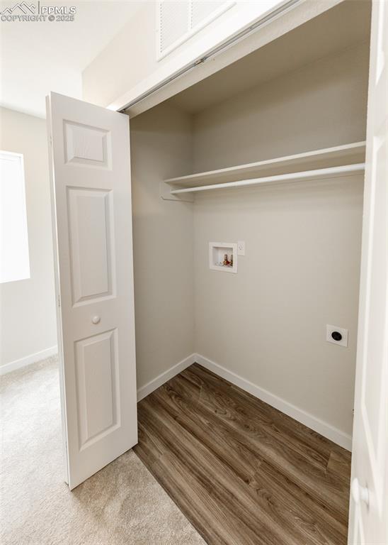 Laundry area featuring light wood-style flooring, hookup for a washing machine, electric dryer hookup, and light colored carpet