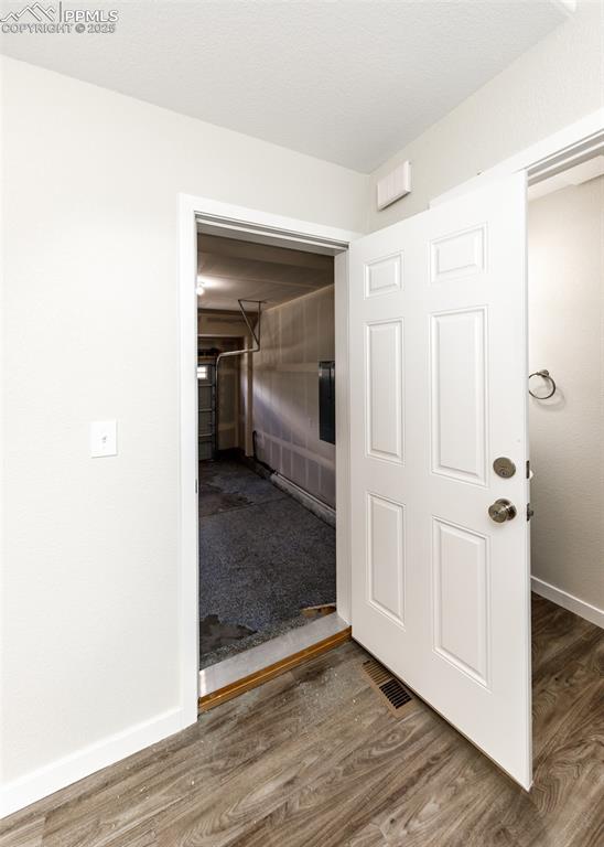 Hallway with baseboards and wood finished floors
