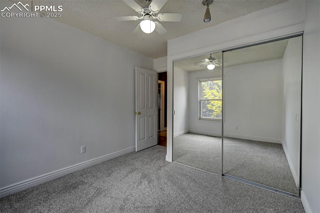  bedroom featuring carpet flooring, a textured ceiling, a closet, and ceiling fan