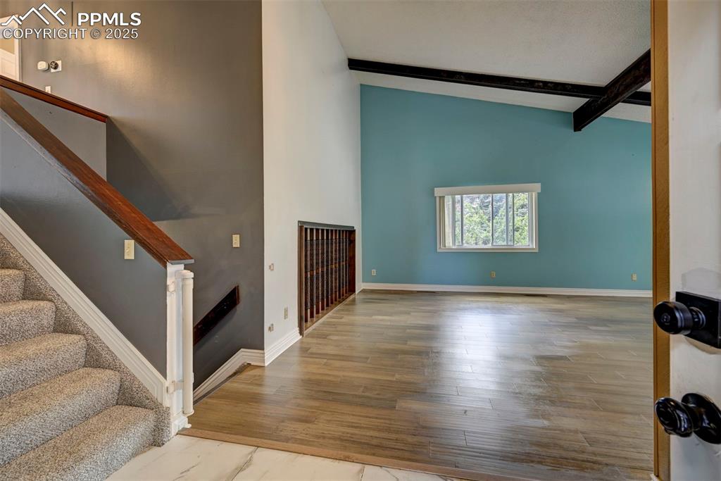 Unfurnished living room with wood finished floors and stairs
