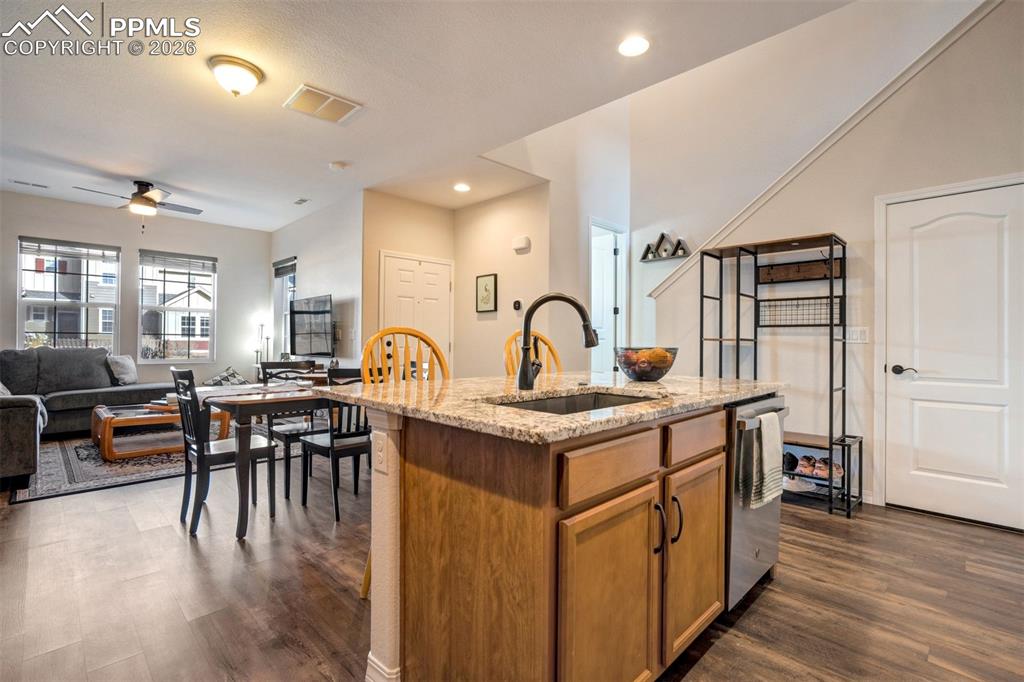 Kitchen island with deep sink, and breakfast bar area. Showing the front door and the door on the right of the photo is understairs storage.