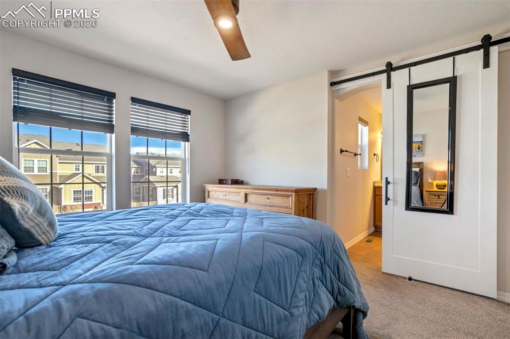 Bedroom featuring a barn door into the primary bathroom. 