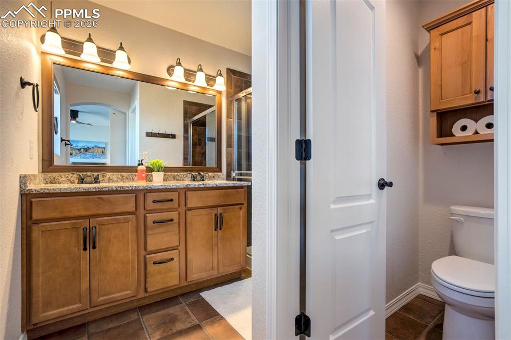 Primary bathroom showing the double vanities, wood cabinets and separate toilet room.  