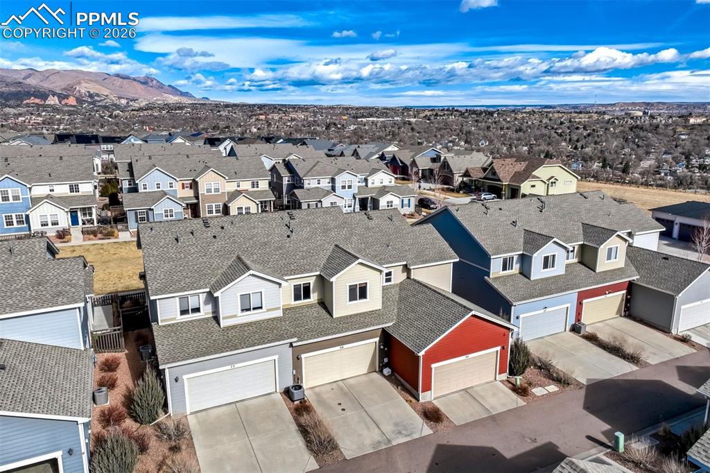 Drone / aerial view of the rear of the property and showing the community and the mountains and rock formations.