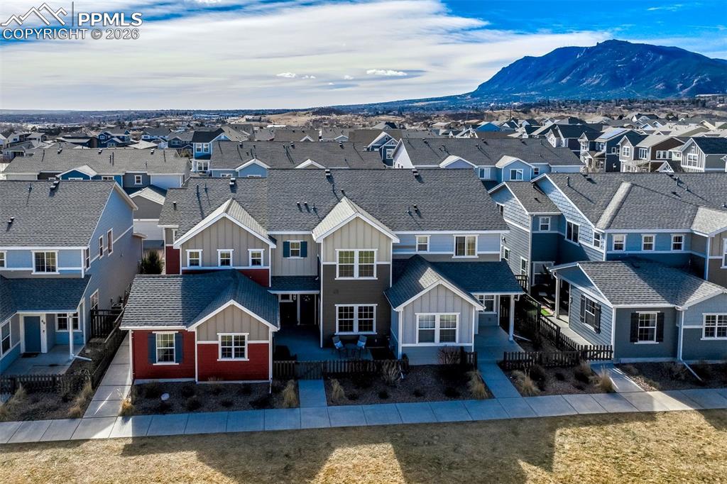 Aerial view of residential area featuring a mountainous background.  The townhome is the red/beige and brown structure.