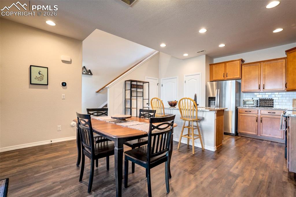 Dining area open to the kitchen and showing staircase. Recessed lighting.