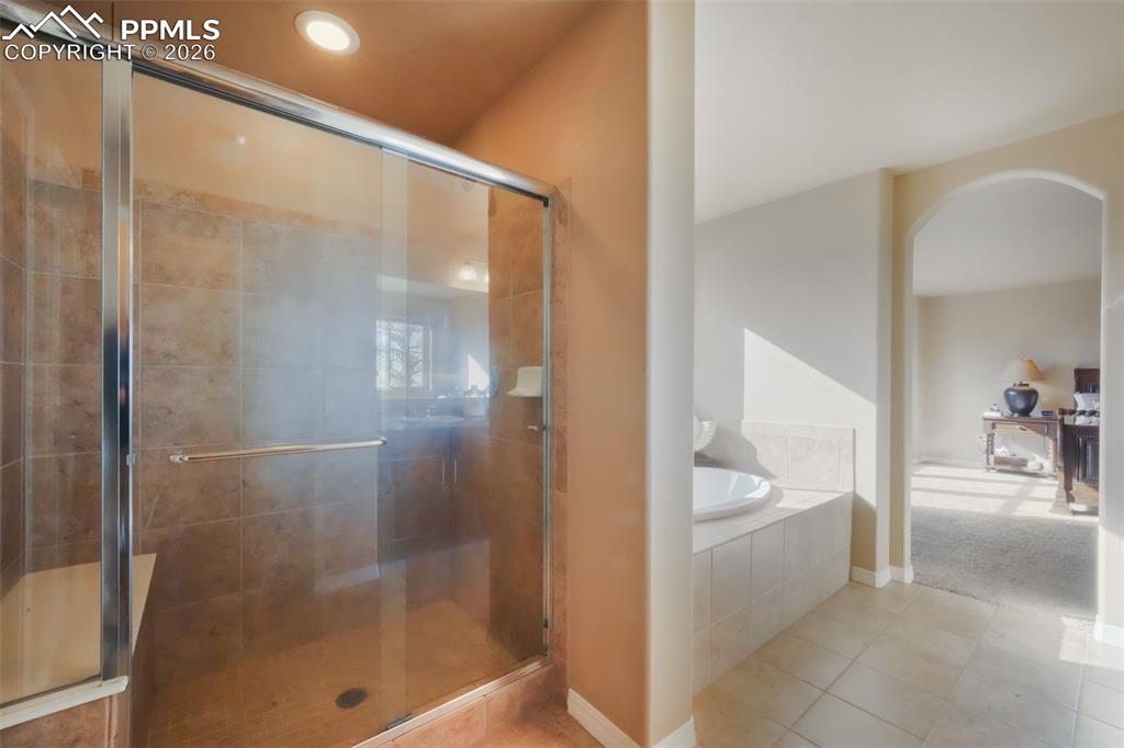 Primary bathroom with dual vanities, soaking tub, large shower, and walk in closet