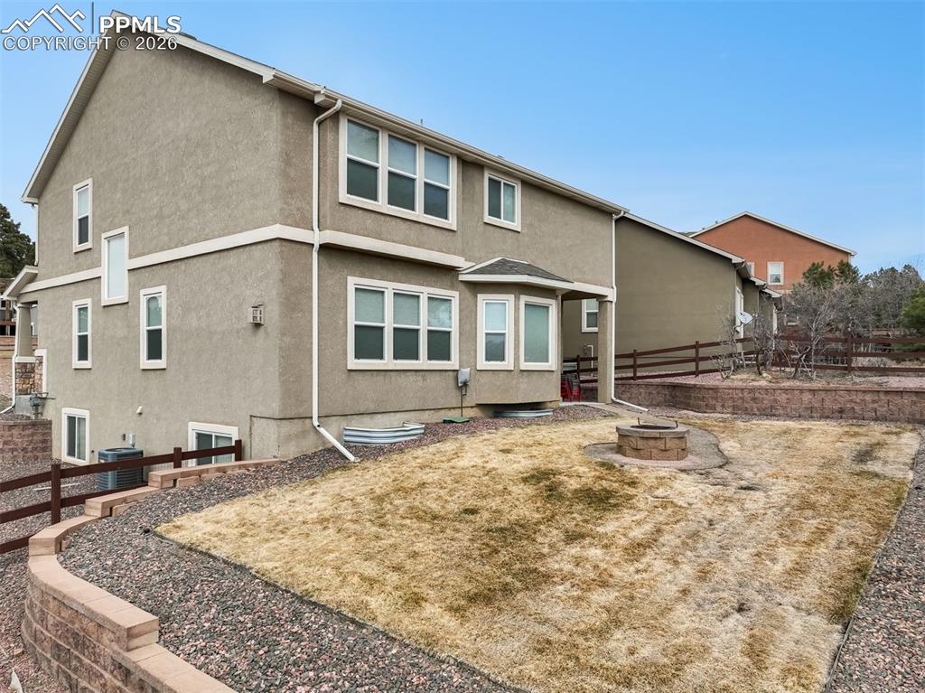 Fenced back yard with landscaping, sprinklers, fire pit and patio access