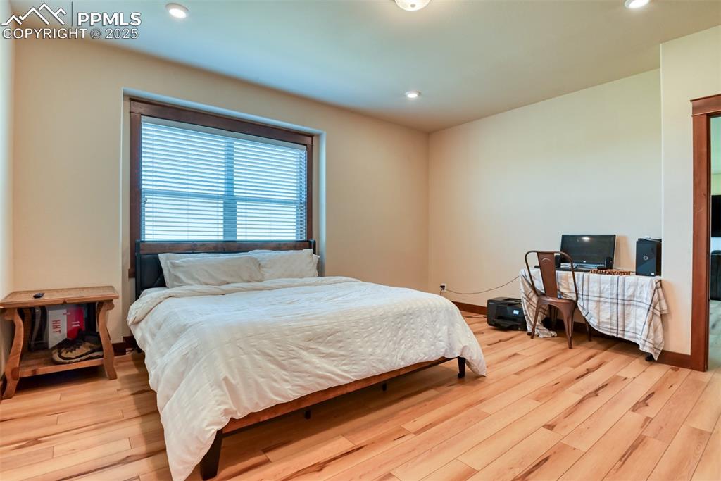 Bedroom featuring LVT wood style floors and recessed lighting