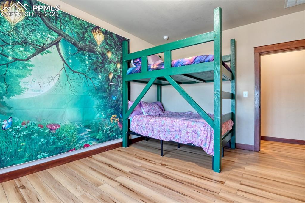 Bedroom featuring LVT wood style floors 
