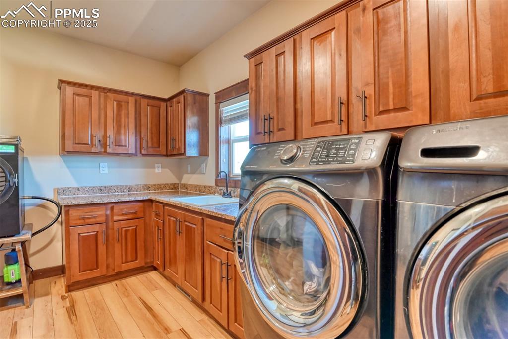 Washroom with washer and dryer, cabinet space, and LVT wood style flooring