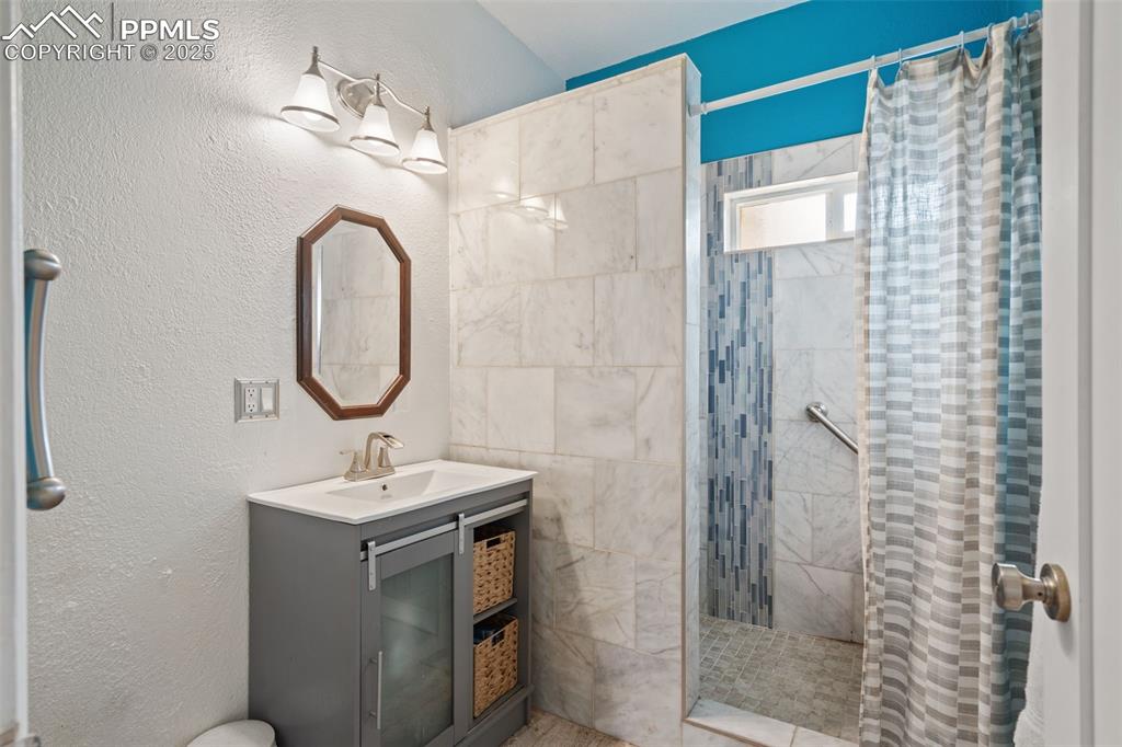Bathroom in main home with marble tile walk-in shower with built in bench. 