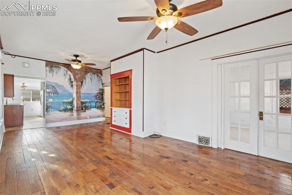 Living/dining room in the main home. Hickory wood floors and Pella windows! French doors lead to Primary Bedroom. 