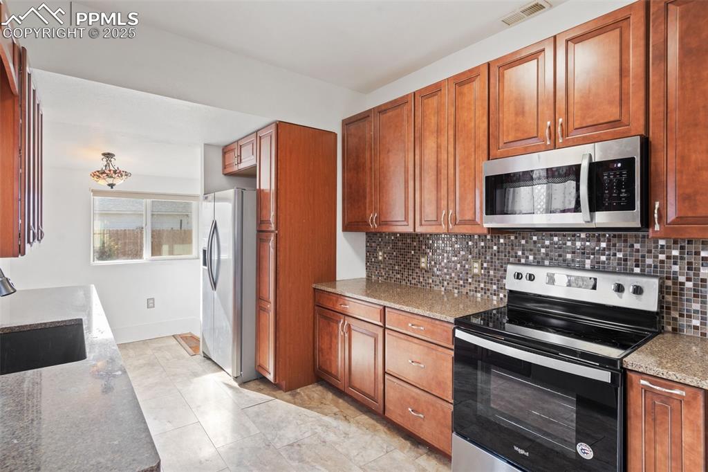 Kitchen in main home with granite counters, 42" upper cabinets and stainless steel appliances. 
