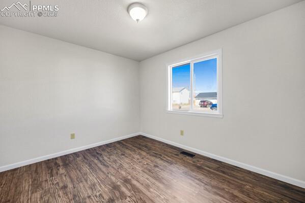 Empty room featuring dark wood-style floors and a textured ceiling
